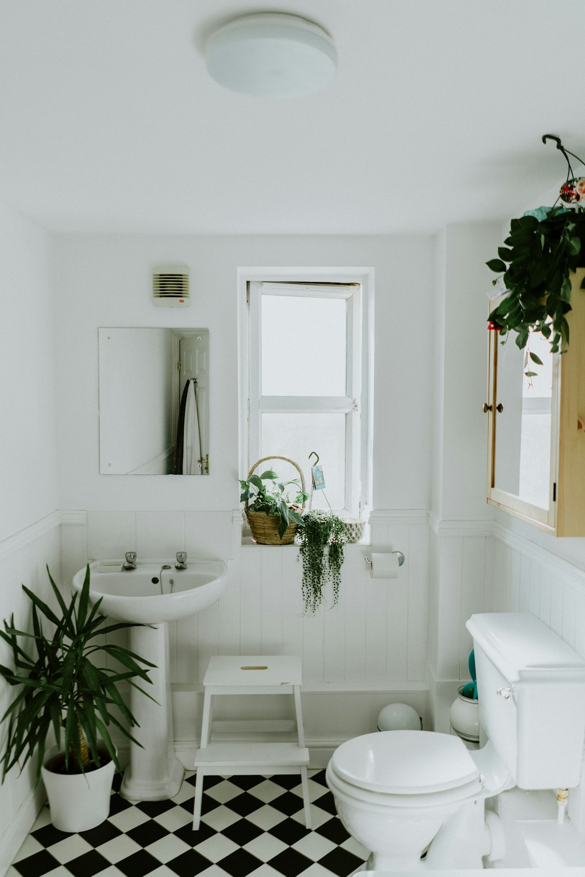 Vintage craftsman bathroom with white wainscoting and classic checkerboard floor tile